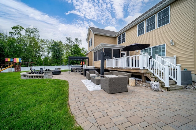 view of patio featuring a wooden deck, an outdoor living space, a sunroom, and a playground