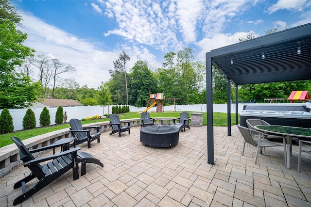 view of patio with a fire pit, a playground, a fenced backyard, and outdoor dining space