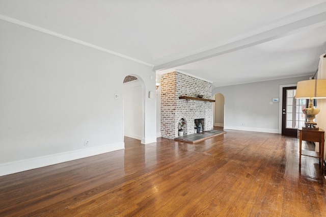 2600 Garden St, Baldwin, NY 11510 - unfurnished living room featuring arched walkways, wood finished floors, a brick fireplace, baseboards, and ornamental molding