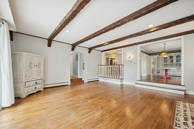 2600 Garden St, Baldwin, NY 11510 - unfurnished living room with wood finished floors, beamed ceiling, baseboards, baseboard heating, and a baseboard heating unit
