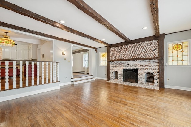 2600 Garden St, Baldwin, NY 11510 - unfurnished living room with wood finished floors, baseboards, beam ceiling, a fireplace, and a baseboard heating unit