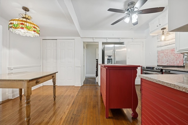 2600 Garden St, Baldwin, NY 11510 - kitchen with stainless steel appliances, hardwood / wood-style flooring, a ceiling fan, white cabinetry, and light countertops