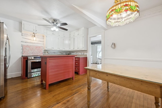 2600 Garden St, Baldwin, NY 11510 - kitchen with stainless steel appliances, ceiling fan, wood-type flooring, and white cabinets