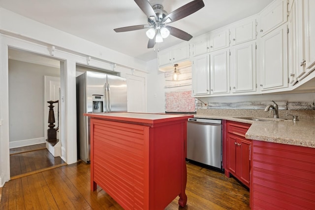 2600 Garden St, Baldwin, NY 11510 - kitchen featuring appliances with stainless steel finishes, dark wood-style flooring, a center island, a ceiling fan, and white cabinets