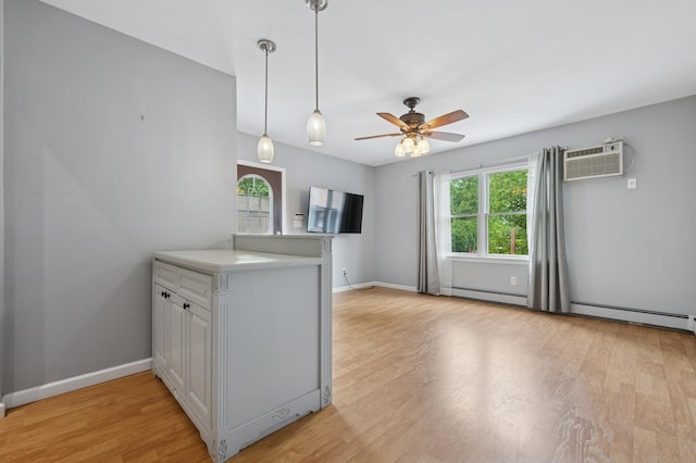 2600 Garden St, Baldwin, NY 11510 - kitchen featuring a wall unit AC, a peninsula, a baseboard radiator, light wood finished floors, and a ceiling fan