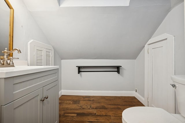 2600 Garden St, Baldwin, NY 11510 - bathroom featuring toilet, lofted ceiling, vanity, wood finished floors, and baseboards