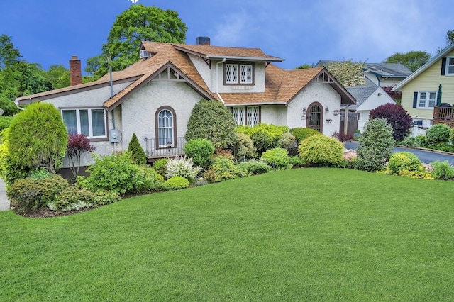 2600 Garden St, Baldwin, NY 11510 - tudor-style house featuring stucco siding, a chimney, a front yard, and roof with shingles