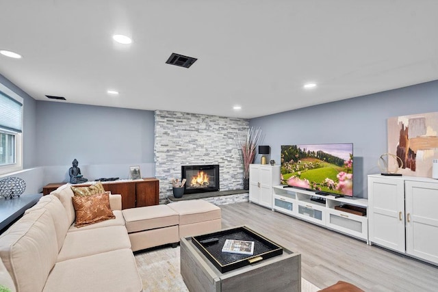 181 Central Park Rd E, Plainview, NY 11803 - living area with light wood finished floors, a stone fireplace, and recessed lighting
