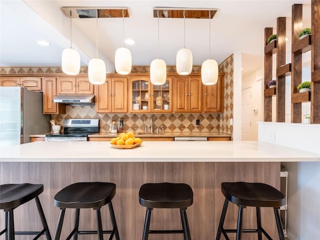 94 Shadyside Ave, Port Washington, NY 11050 - kitchen with electric stove, under cabinet range hood, light countertops, backsplash, and recessed lighting