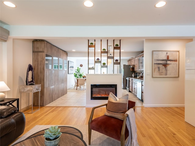 94 Shadyside Ave, Port Washington, NY 11050 - living area featuring light wood finished floors, recessed lighting, a glass covered fireplace, baseboards, and an AC wall unit