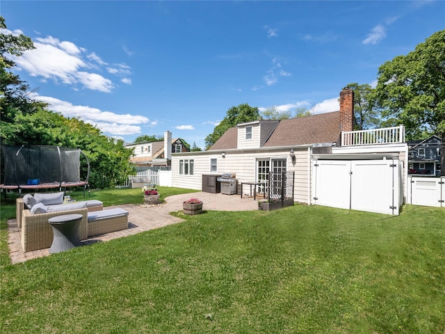 94 Shadyside Ave, Port Washington, NY 11050 - back of house featuring a trampoline, a patio area, a chimney, and roof with shingles