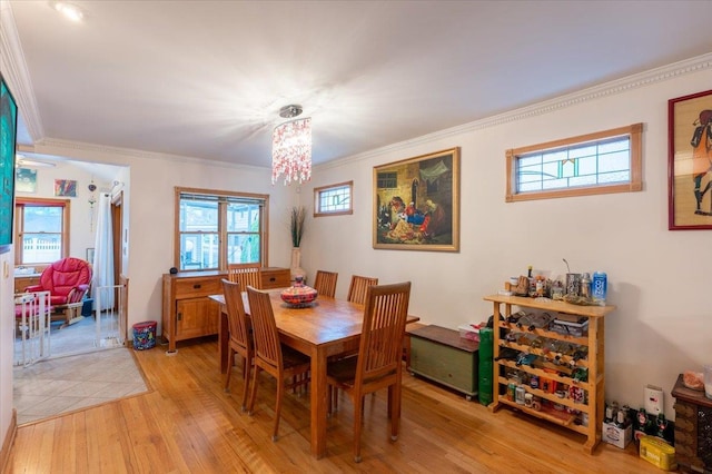 dining area with light wood-style floors and crown molding