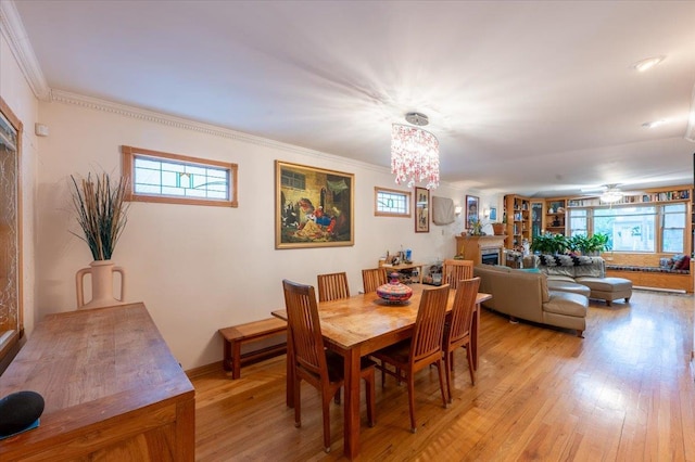 dining area with light wood finished floors, plenty of natural light, and ornamental molding