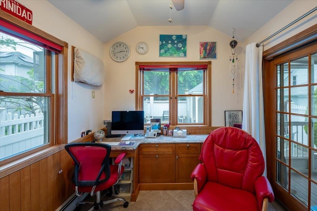 home office with vaulted ceiling, plenty of natural light, and light tile patterned flooring
