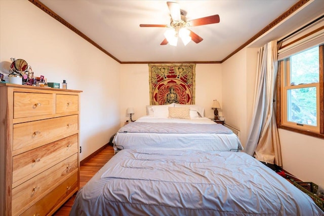 bedroom featuring wood finished floors, crown molding, and ceiling fan