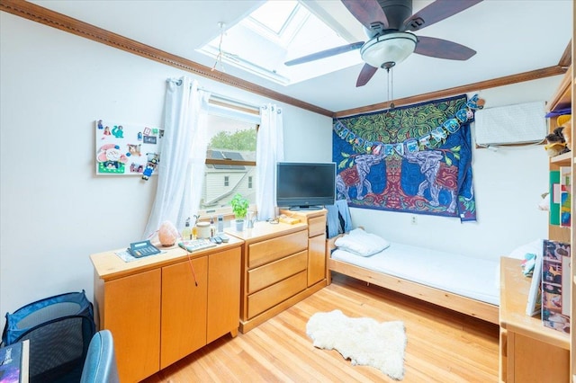bedroom featuring a skylight, crown molding, and light wood finished floors