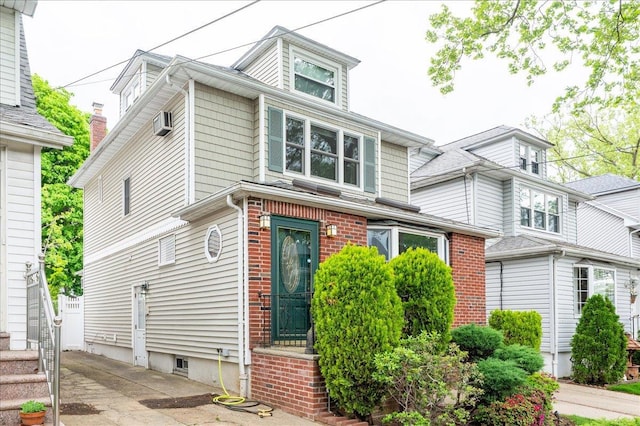 american foursquare style home with a wall mounted air conditioner
