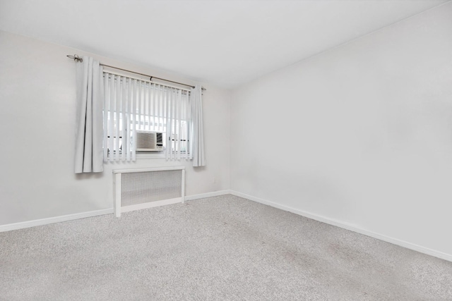 unfurnished living room with radiator heating unit, baseboards, carpet floors, and cooling unit