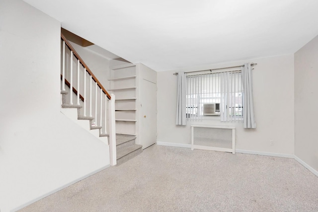 unfurnished living room with radiator, stairway, baseboards, and cooling unit
