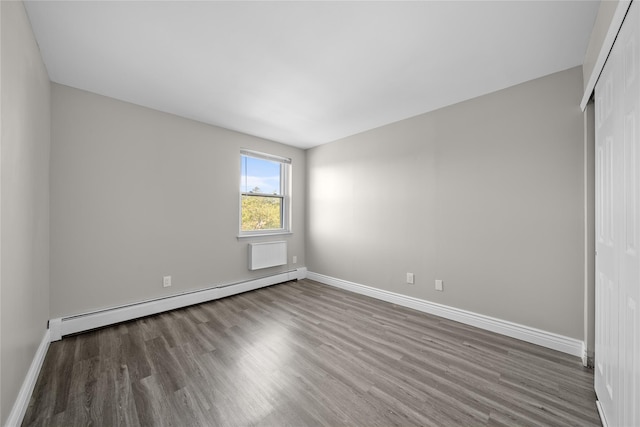280 Lowndes Ave Unit 305G, Huntington Station, NY 11746 - unfurnished bedroom with a baseboard heating unit, wood finished floors, baseboards, and a closet