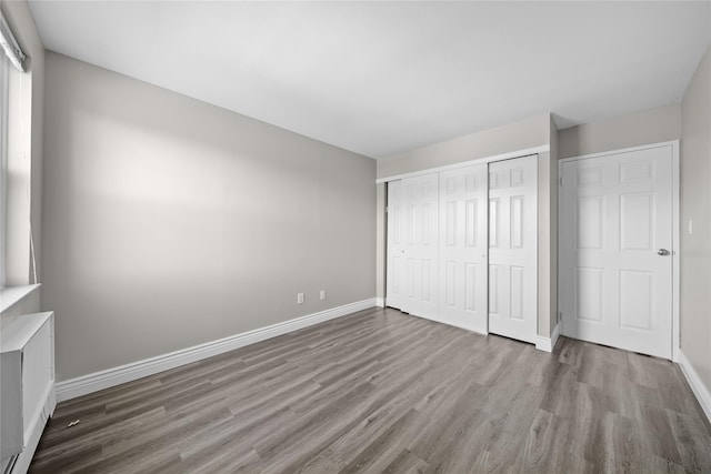 280 Lowndes Ave Unit 305G, Huntington Station, NY 11746 - unfurnished bedroom featuring wood finished floors, baseboards, and a closet