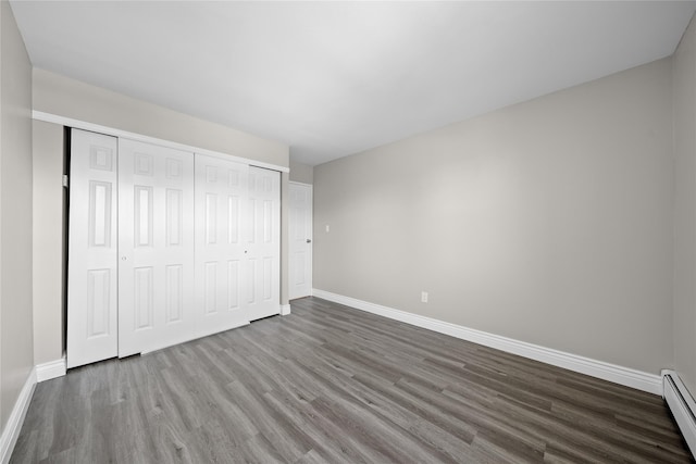 280 Lowndes Ave Unit 305G, Huntington Station, NY 11746 - unfurnished bedroom with baseboards, wood finished floors, baseboard heating, and a closet