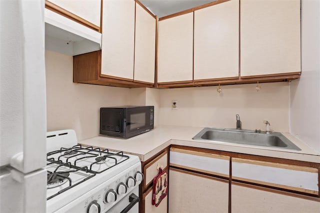 110-20 71st Ave Unit 106, Forest Hills, NY 11375 - kitchen with white range with gas stovetop, black microwave, a sink, light countertops, and white cabinets