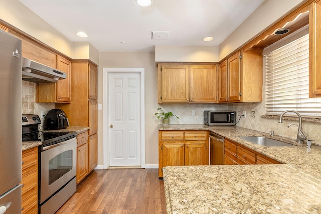10 Northwood Ct, Dix Hills, NY 11746 - kitchen with appliances with stainless steel finishes, under cabinet range hood, a sink, backsplash, and light wood finished floors