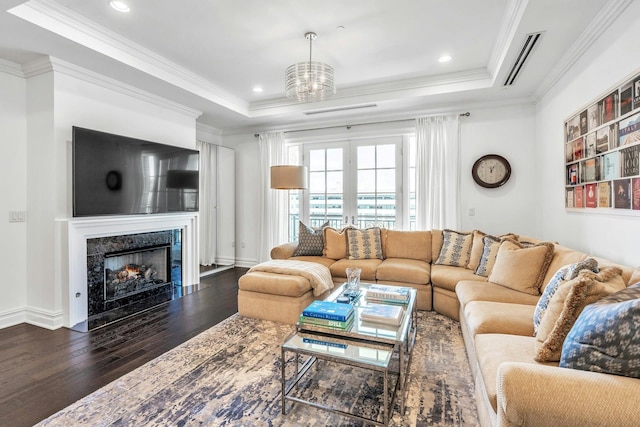 living area featuring dark wood-style flooring, a raised ceiling, crown molding, a fireplace, and recessed lighting