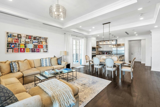 living room featuring a raised ceiling, dark wood-style flooring, crown molding, baseboards, and recessed lighting