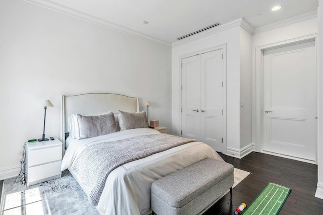 bedroom featuring a closet, wood finished floors, crown molding, baseboards, and recessed lighting