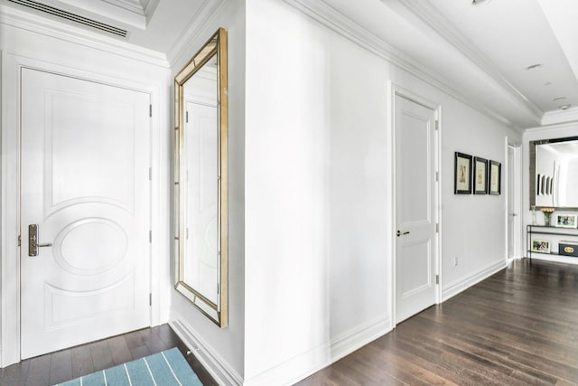 foyer with dark wood-type flooring, crown molding, and baseboards