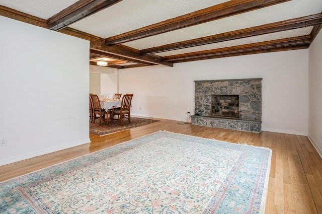12 Glenn Pl, Hastings-On-Hudson, NY 10706 - living room featuring wood finished floors, baseboards, beamed ceiling, and a stone fireplace