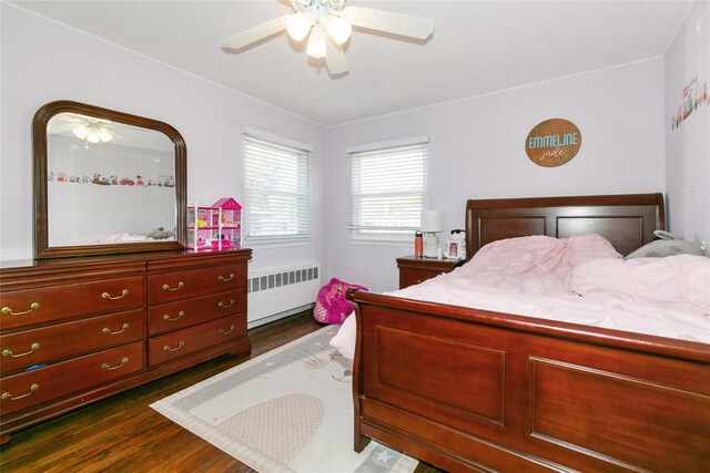 bedroom with radiator, dark wood-type flooring, and a ceiling fan
