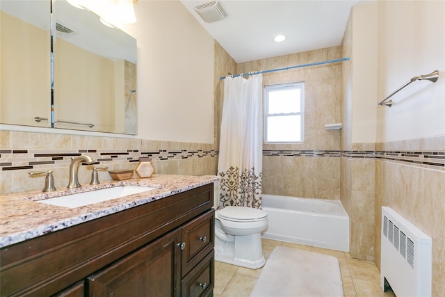 full bath featuring radiator heating unit, tile walls, toilet, shower / tub combo with curtain, and vanity