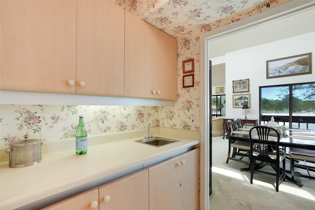 16 Waters Edge Unit 16, Rye, NY 10580 - kitchen featuring a sink, wallpapered walls, light countertops, light carpet, and light brown cabinetry