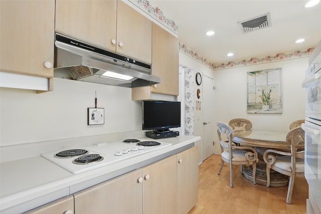16 Waters Edge Unit 16, Rye, NY 10580 - kitchen with under cabinet range hood, light countertops, white electric cooktop, light brown cabinets, and recessed lighting