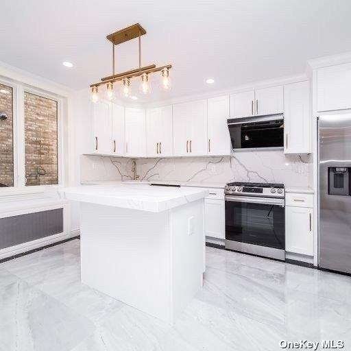 kitchen featuring appliances with stainless steel finishes, light marble finish flooring, white cabinetry, decorative backsplash, and recessed lighting