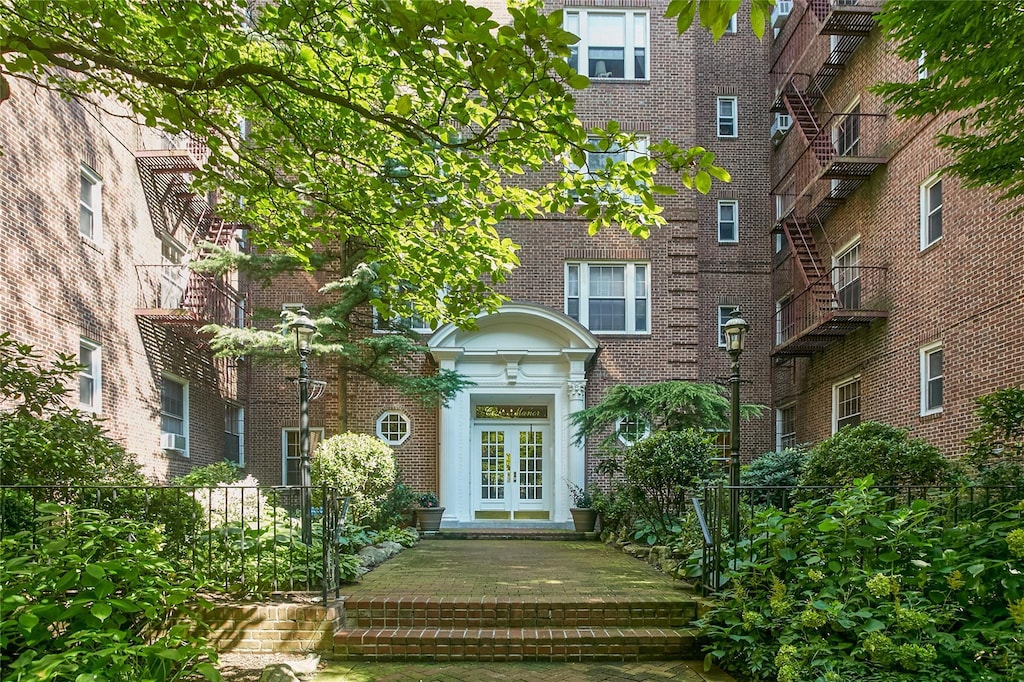 property entrance featuring french doors and brick siding