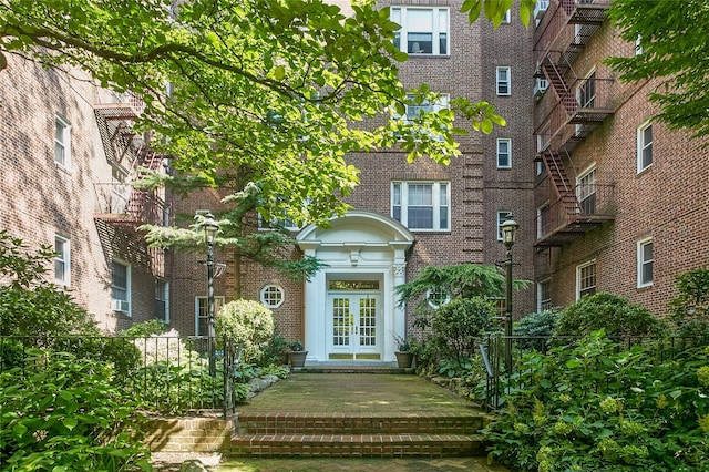 property entrance featuring french doors and brick siding