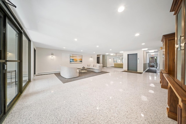 unfurnished living room featuring a baseboard heating unit, speckle patterned floor, and recessed lighting