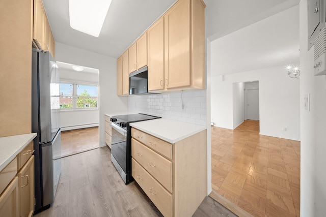 kitchen featuring electric range oven, freestanding refrigerator, light brown cabinetry, a baseboard heating unit, and light countertops