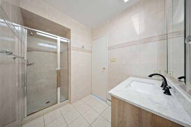 full bath with tile patterned floors, a stall shower, tile walls, and vanity