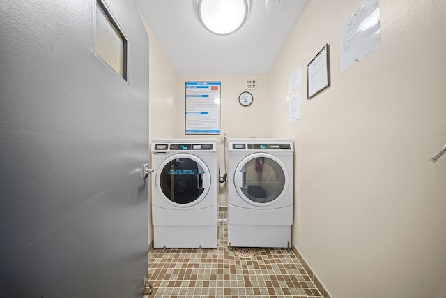 community laundry featuring washing machine and clothes dryer and baseboards