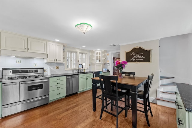 70 Willow Ln, New Windsor, NY 12553 - kitchen featuring appliances with stainless steel finishes, under cabinet range hood, a sink, dark countertops, and light wood-style flooring