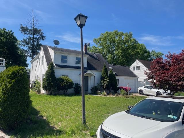 664 Bryant St, Westbury, NY 11590 - view of front of property featuring a front yard and a garage