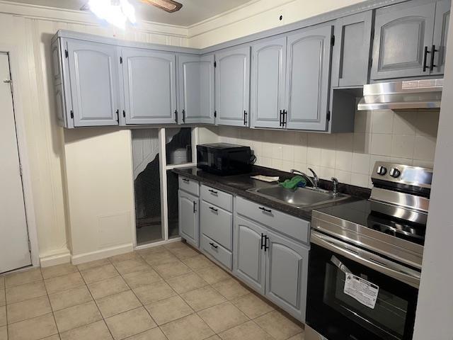 664 Bryant St, Westbury, NY 11590 - kitchen featuring stainless steel electric range oven, under cabinet range hood, a sink, dark countertops, and black microwave