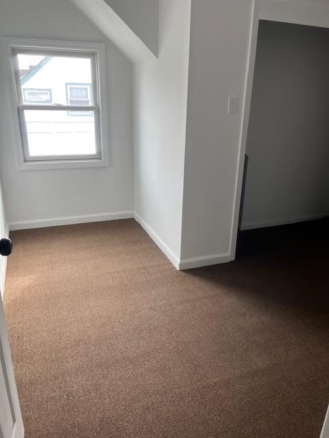 664 Bryant St, Westbury, NY 11590 - additional living space featuring dark colored carpet and baseboards