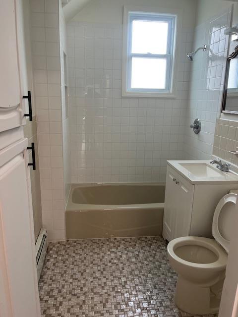 664 Bryant St, Westbury, NY 11590 - bathroom with toilet, tile walls, a baseboard radiator,  shower combination, and vanity