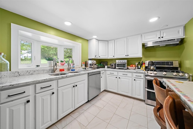180-184 Pine Tree Rd, Monroe, NY 10950 - kitchen with appliances with stainless steel finishes, under cabinet range hood, a sink, white cabinets, and light stone counters